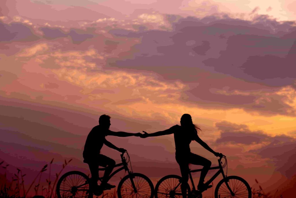 Silueta de pareja paseando en bicicleta